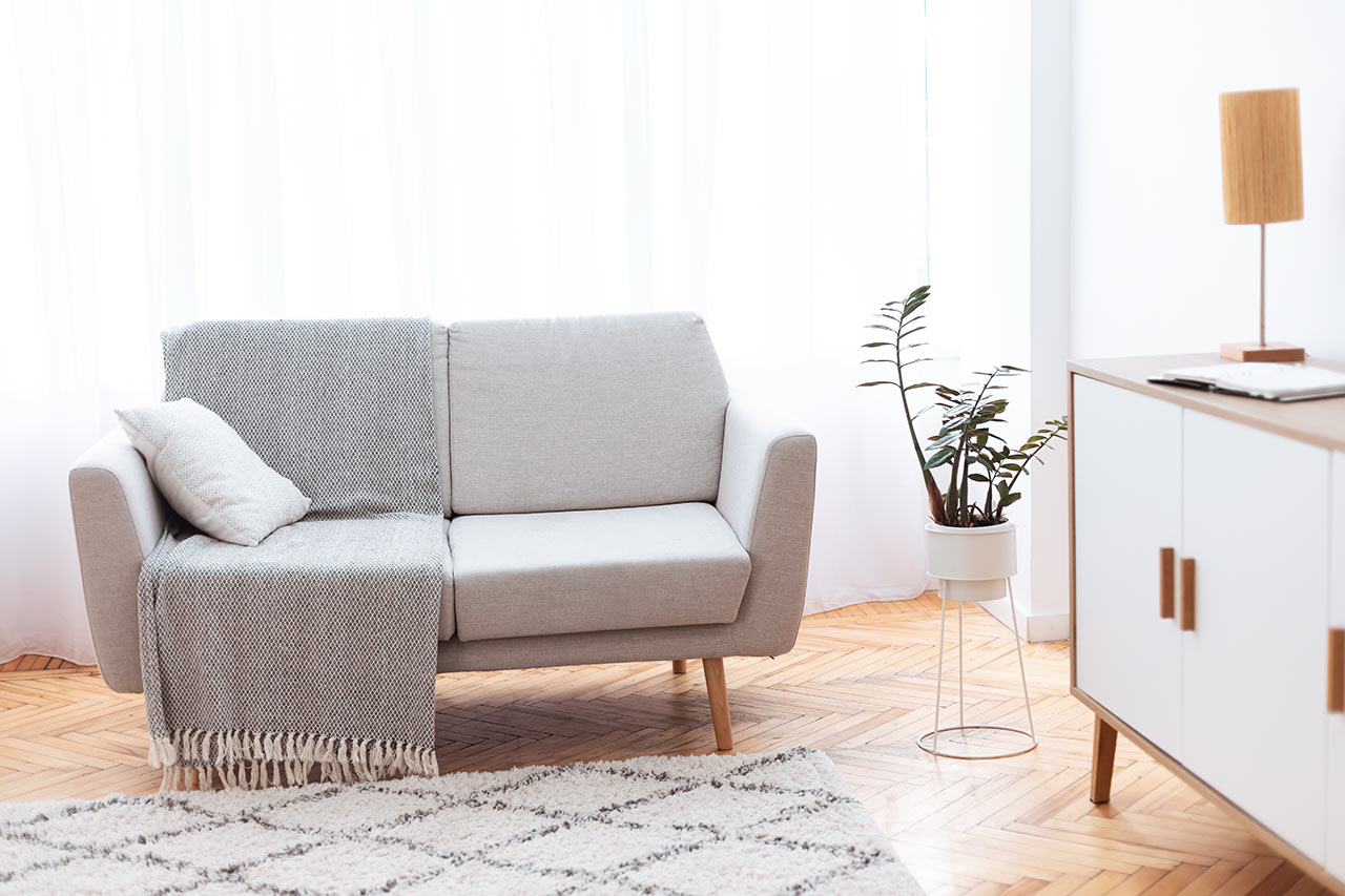 Minimalista nappali világos kanapéval és szekrénnyel