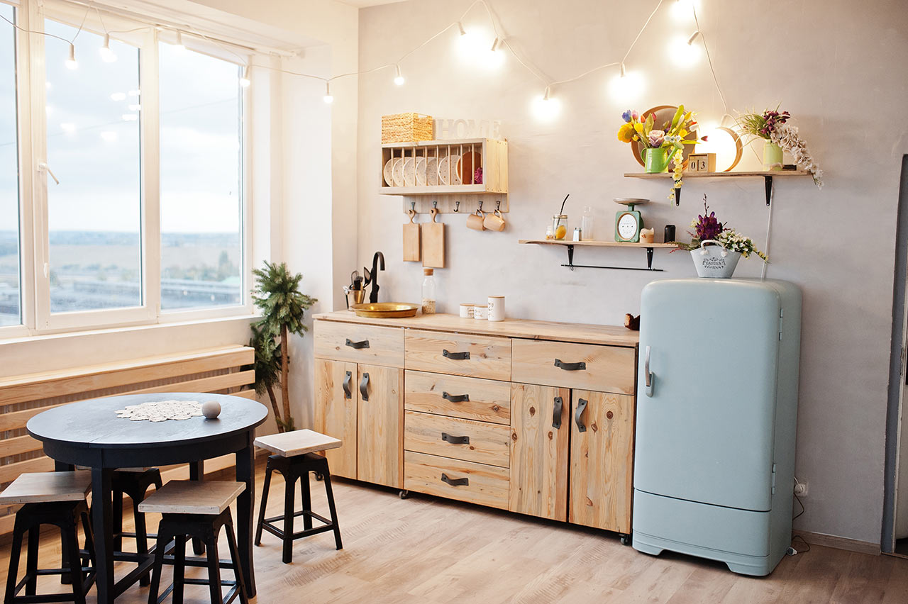 Kis hangulatos konyha fapulttal, asztallal és hűtőszekrénnyel