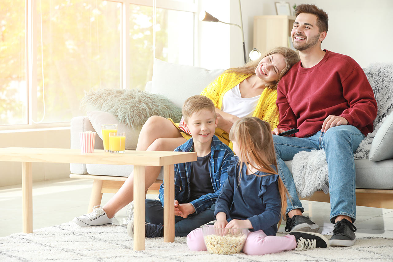Boldog család egy világos, modern és egyszerűen berendezett nappaliban